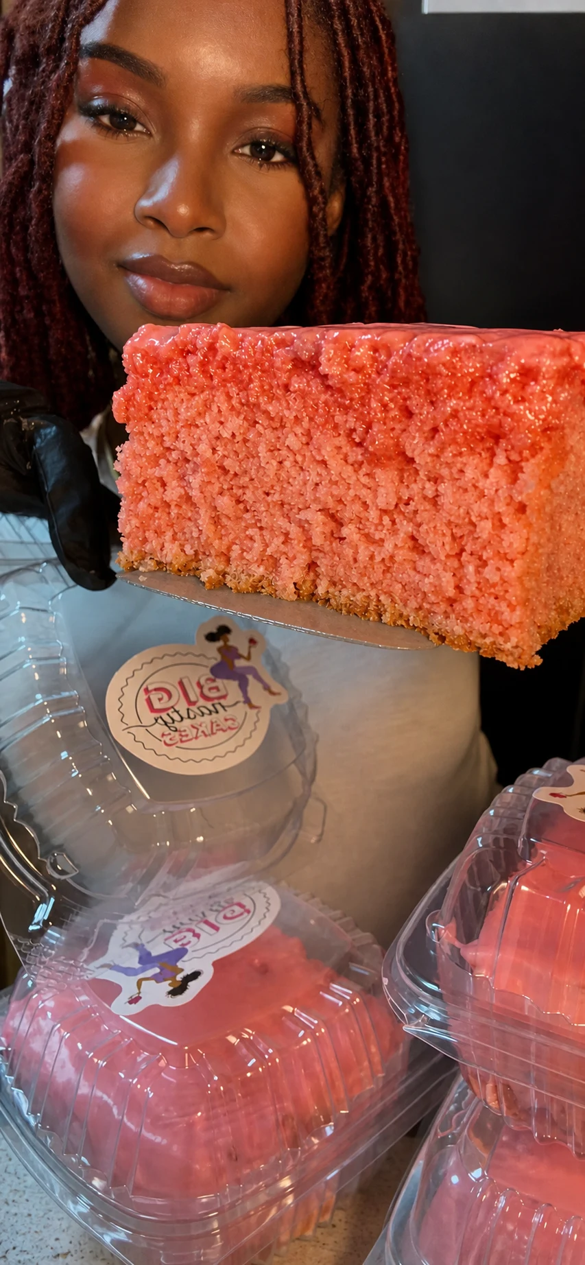 Praise Outing presenting a strawberry cake slice from Big Nasty Cakes.